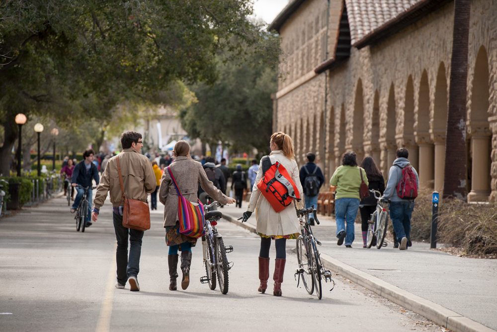 Photo of students riding and walking their bikes.
