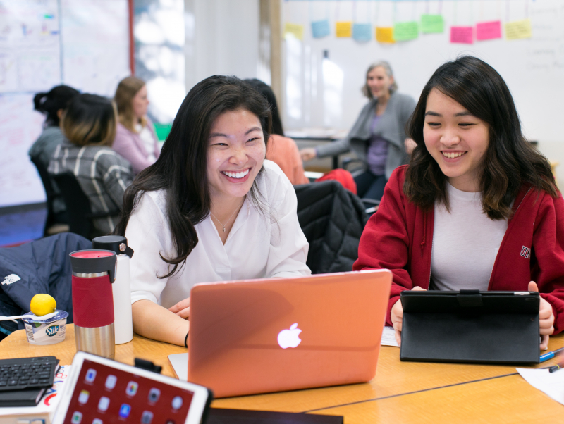 Two female students in front of a laptop.