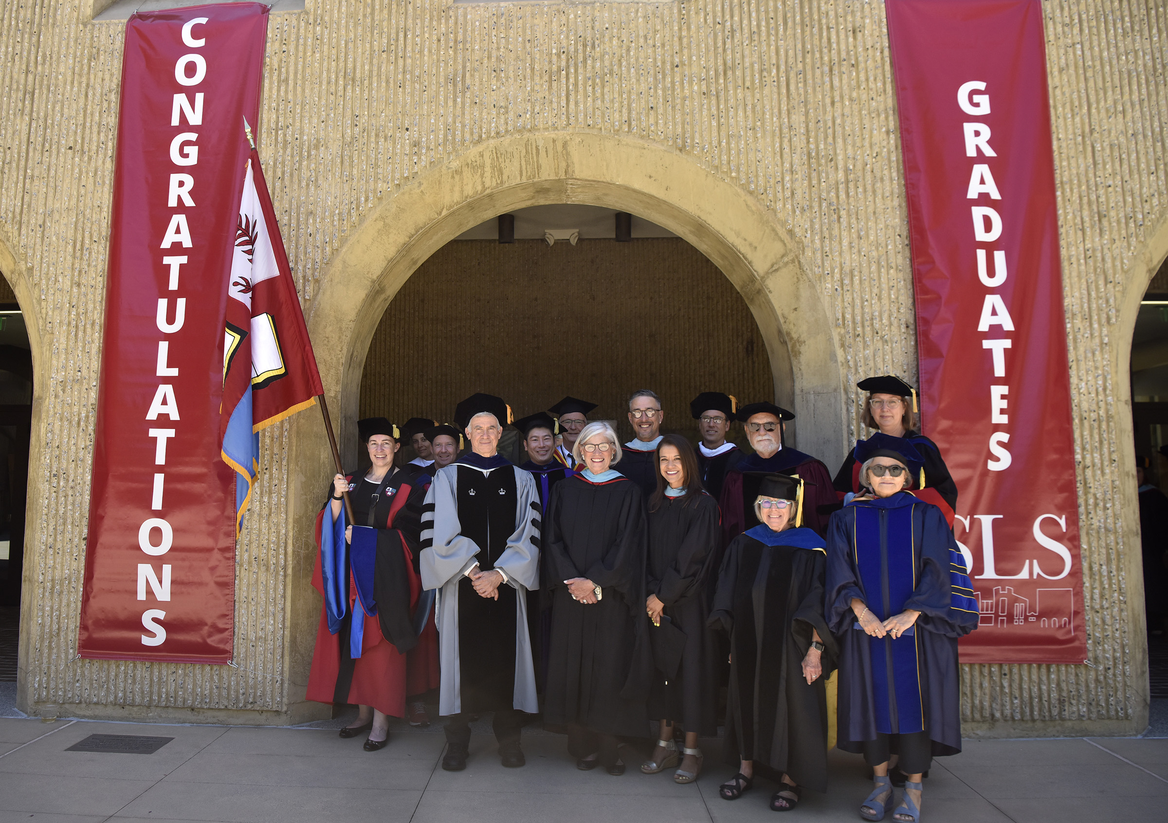 GSE faculty including Dean Dan Schwartz (second from left) and flag bearer Megan Selbach-Allen (far left) lead the procession.
