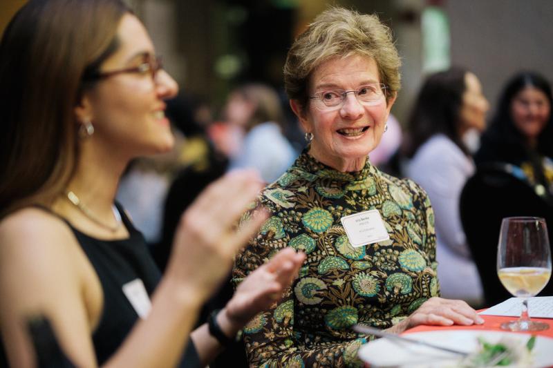 a woman smiles at the guest seated at the table next to her