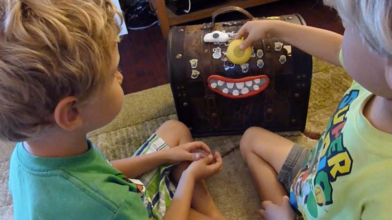 Two kids playing with a chest toy