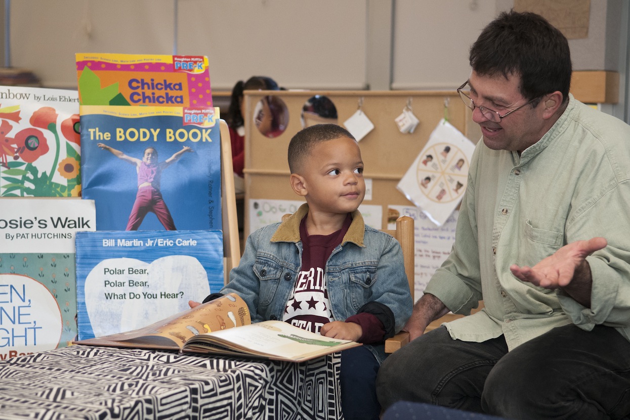 A prekindergarten student reads with a parent volunteer in San Francisco, where Stanford researchers piloted a literacy texting program. (Linda A. Cicero/Stanford News Service)