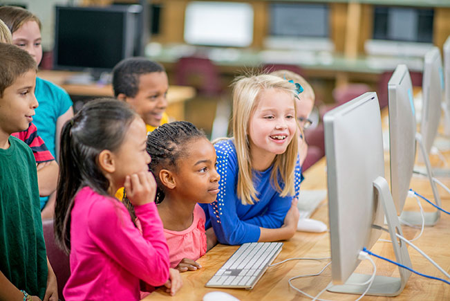 Children with computers in classroom (© Christopher Futcher, iStock)