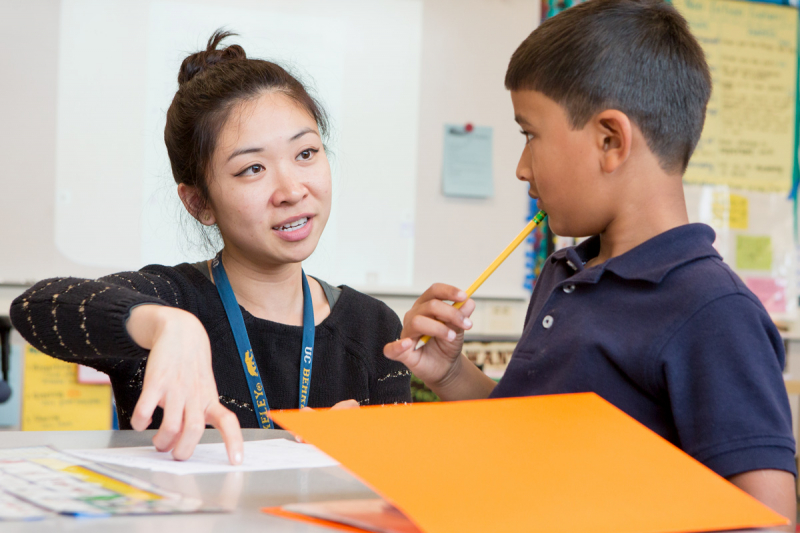 Student teacher explaining something to a student