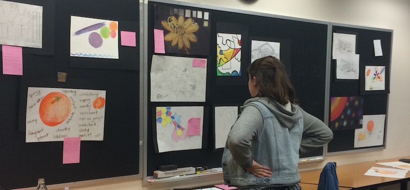 A female student looking at wall of student's work