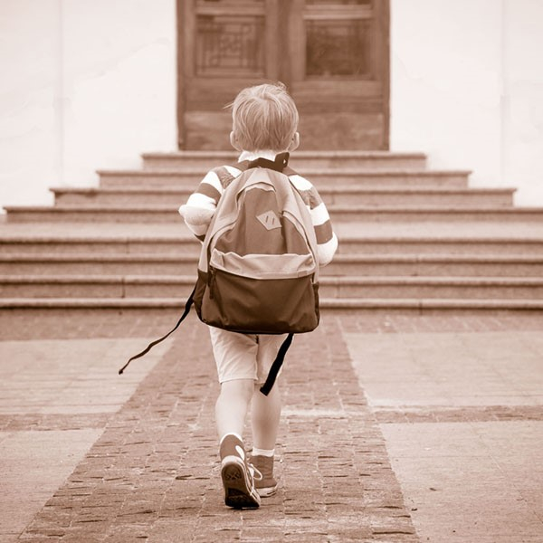 Photo of young student entering a school