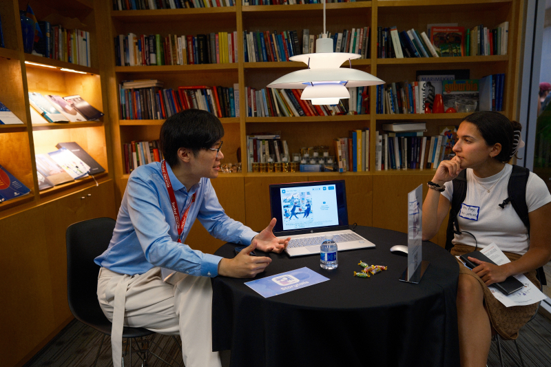 Xingjian Yang (left) demonstrates Storytails, an app that creates a more interactive family reading experience. (Photo: Ryan Zhang)