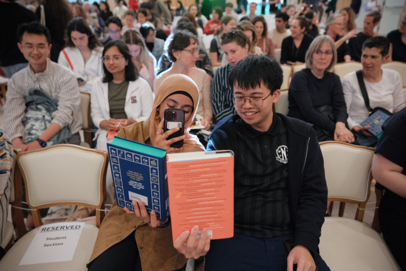 Attendees take pictures of their books before the 2024 Cubberley Lecture with author Bonnie Garmus. (Photo: Ryan Zhang)