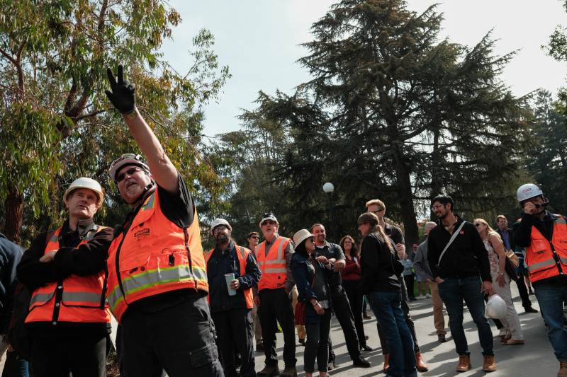 Onlookers watch as the beam is lowered into place at the top of the new south building. (Photo: Ryan Zhang)