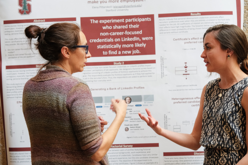 Elena Pittarokoili, MS ’23 (right), presents her capstone project on non-career-focused online credentials. (Photo: Ryan Zhang)