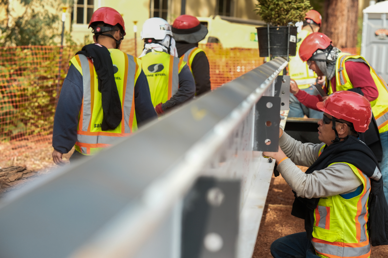Steel workers sign the final beam before it is lifted into place on the south building, October 31, 2023 (photo: Ryan Zhang)