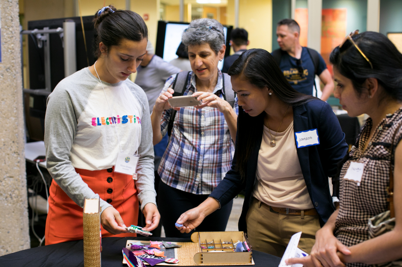 Eileen Rivera (left) shows attendees how to use ElectriStitch, a kit that guides children through the fundamentals of electronic circuits, sewing, design and computation.
