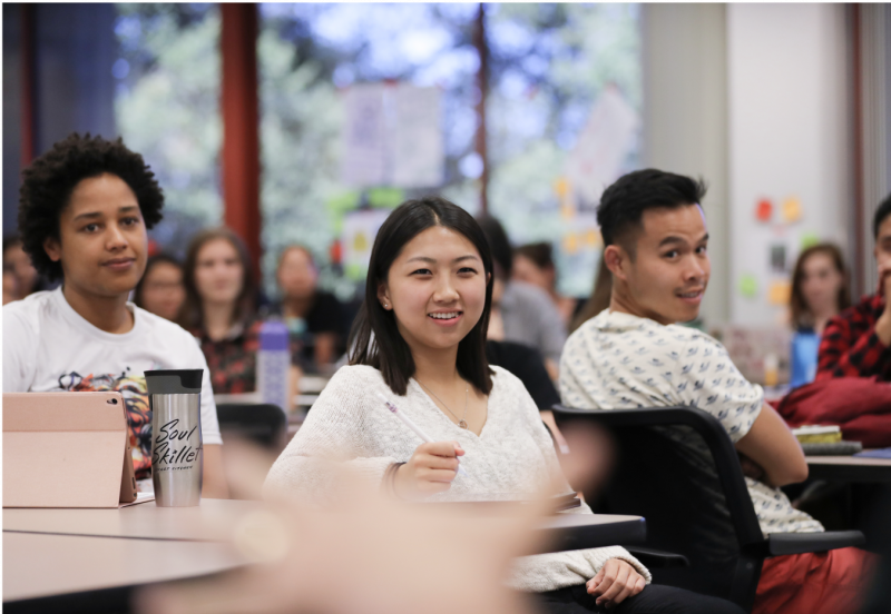 Female student at the table smiling.