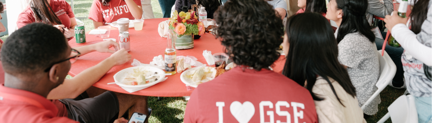 GSE alumni and students sitting around a tailgate table