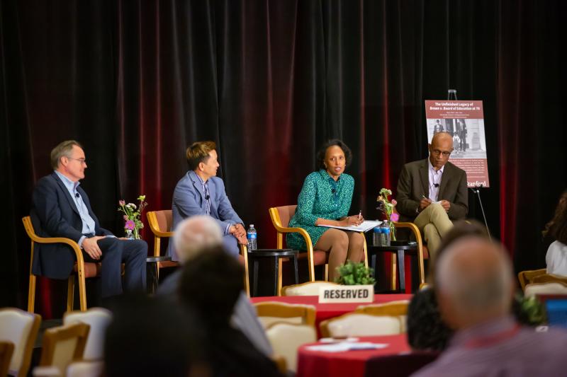 Four panelists on stage.