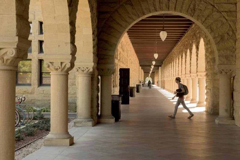 Student crossing a path on a university campus