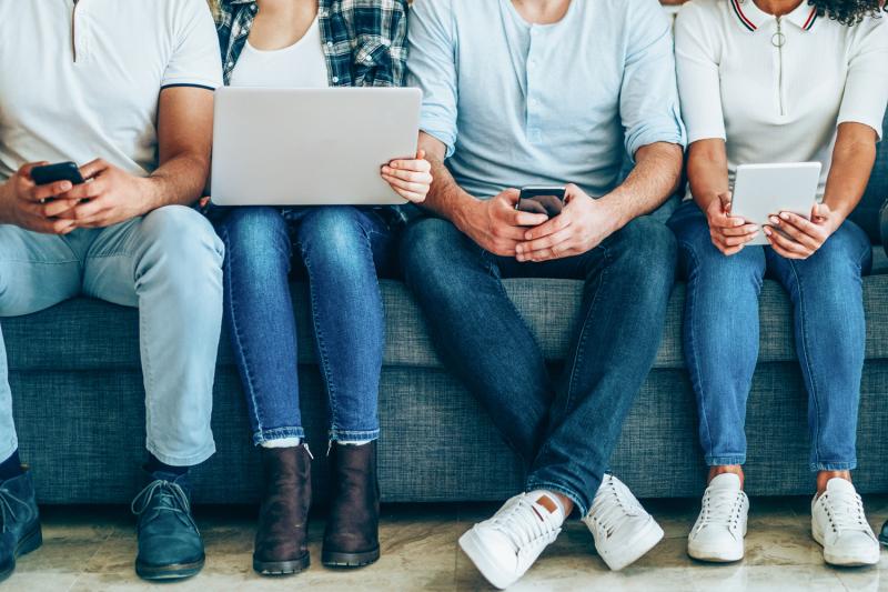 Photo of young people with a variety of online news devices