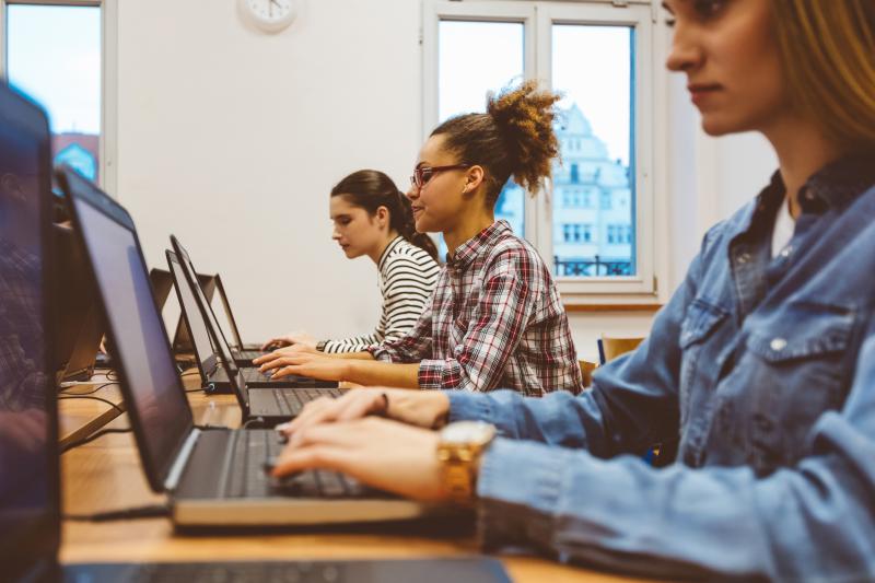 Students sitting in front of a laptop