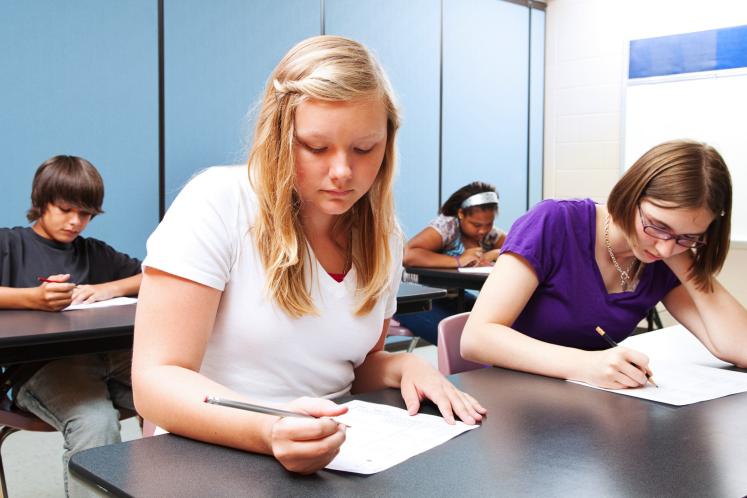 Young teenagers taking an exam.