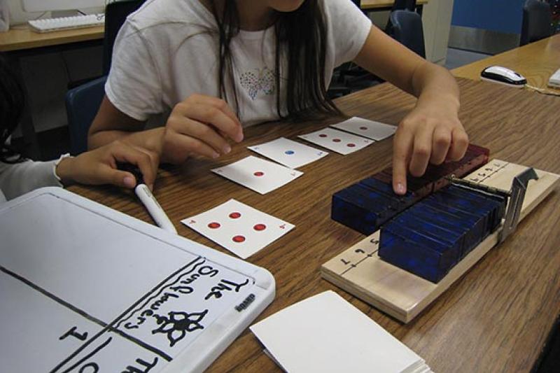 As part of a four-hour curriculum on integers, fourth-grade students played games using a special number line that could be folded in half at the zero point, allowing the symmetry between positive and negative quantities to stand out. (Courtesy of Stanford AAA Lab)