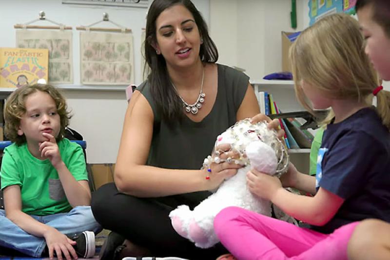 A female teacher interacting with young children