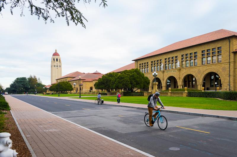 Student riding bicycle on Stanford campus.