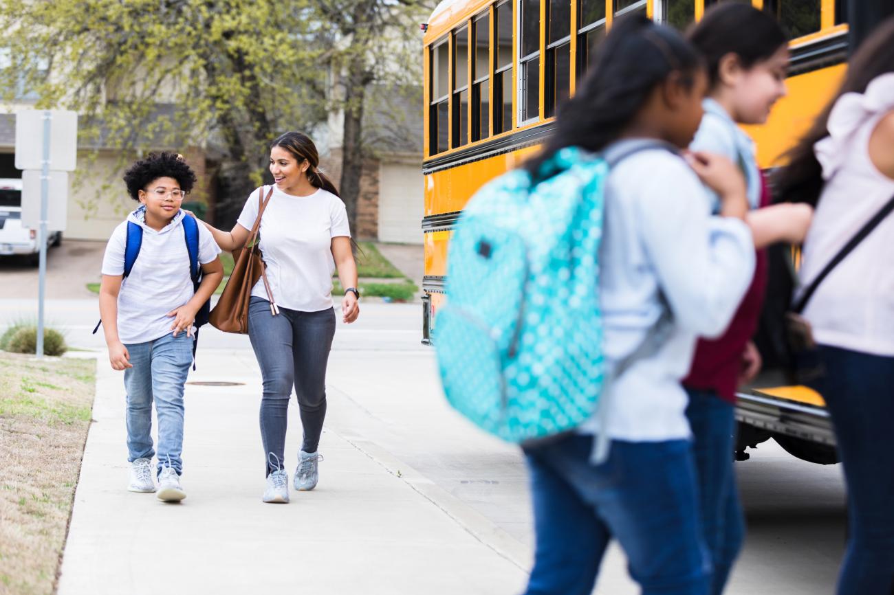 Photo of parent and student walking toward school bus