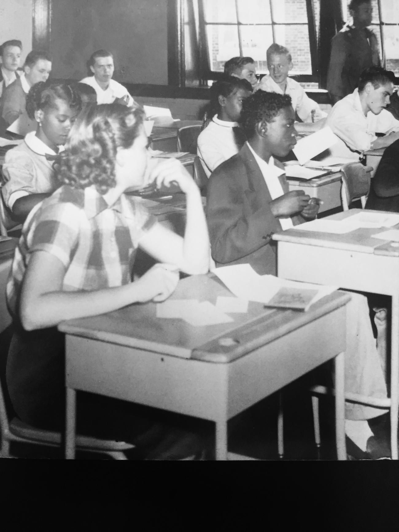 Old photograph of white and black children in a classroom.