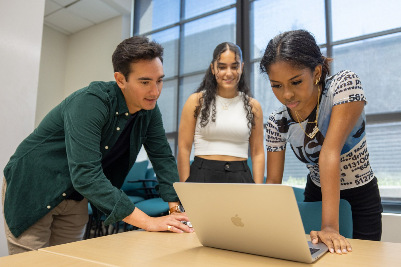 Students collaborating around a computer