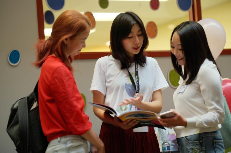 Janet Liu, who co-developed the O Dinos storybook series, shows one of the books at the LDT Expo. (Photo: Ryan Zhang)