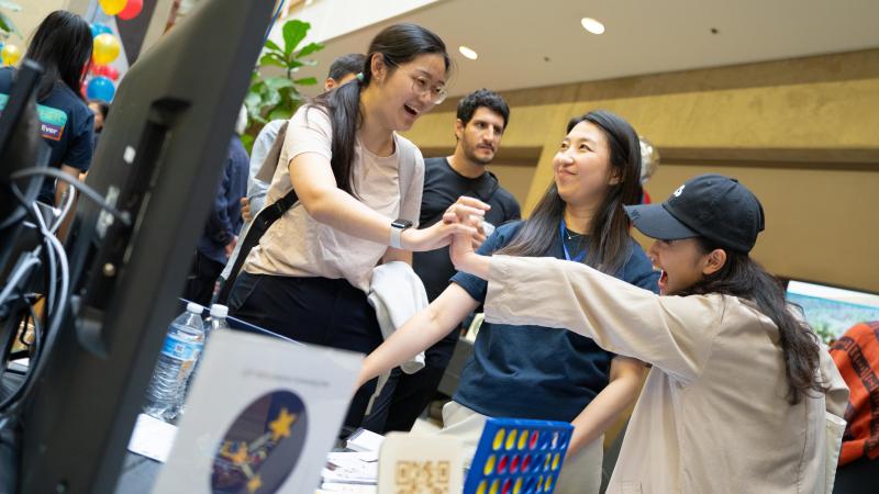 Two guests high five at Expo after successfully using a project. (Photo: Joleen Richards)