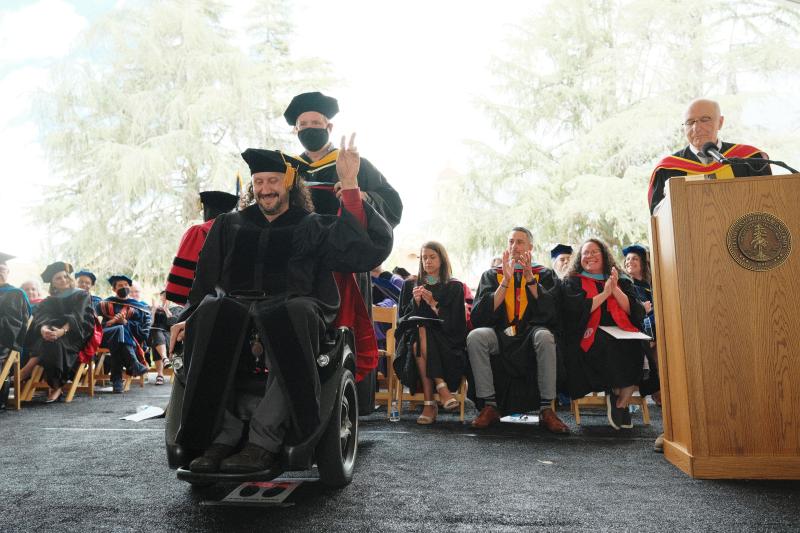 Doctoral graduate Ben Woodford receives his hood.