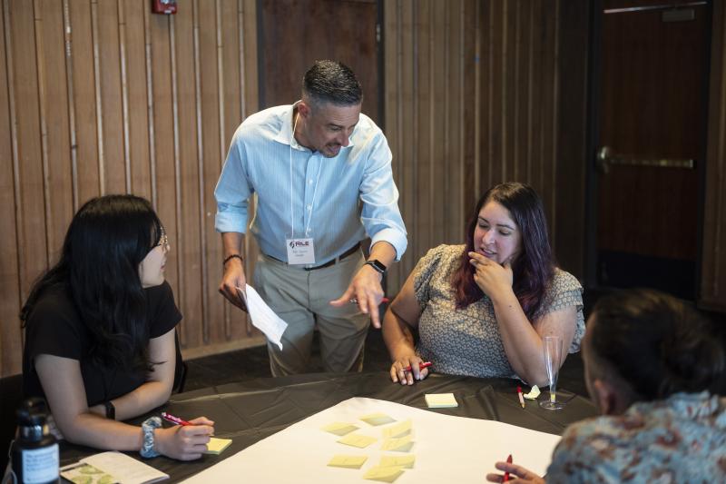 Jeff Camarillo, assistant director of secondary education at STEP (center), aids conference participants. (Photo: Rod Searcey)