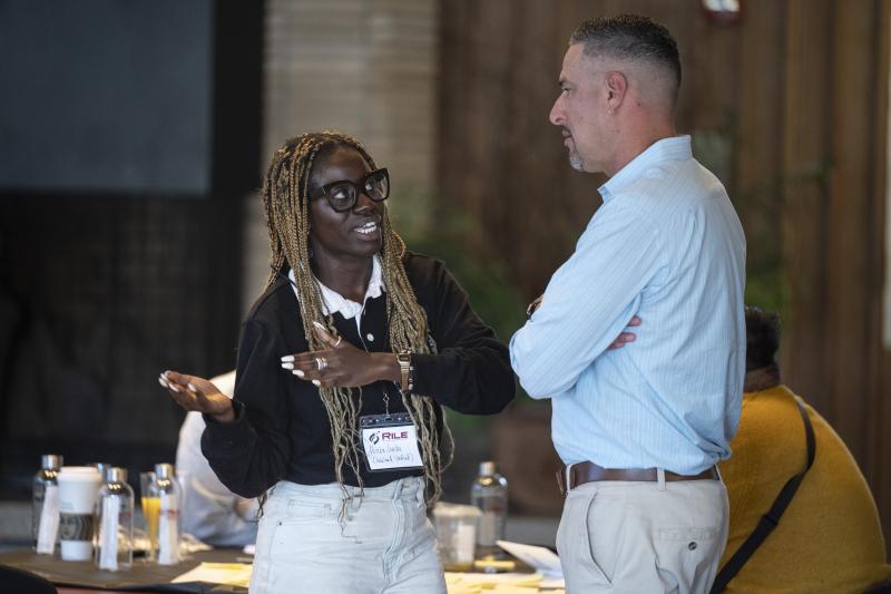 Jeff Camarillo (right), speaks with Alicia Simba, a kindergarten teacher with the Oakland Unified School District. (Photo: Rod Searcey)