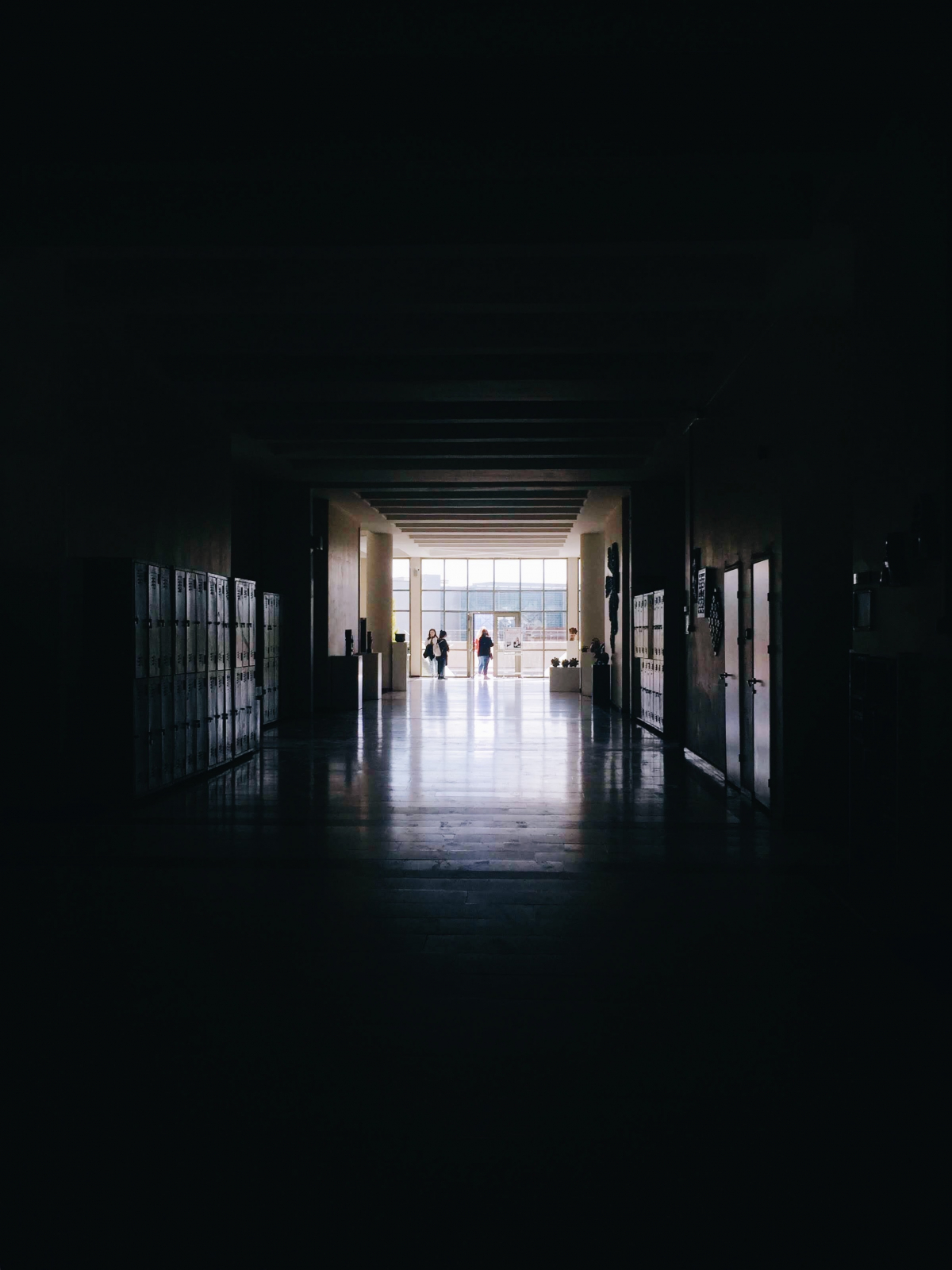 Photo of a dark school hallway opening into the light