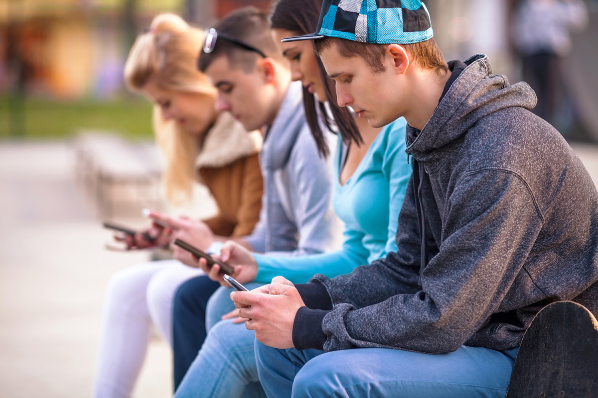 Photo of high school students reading smartphones 