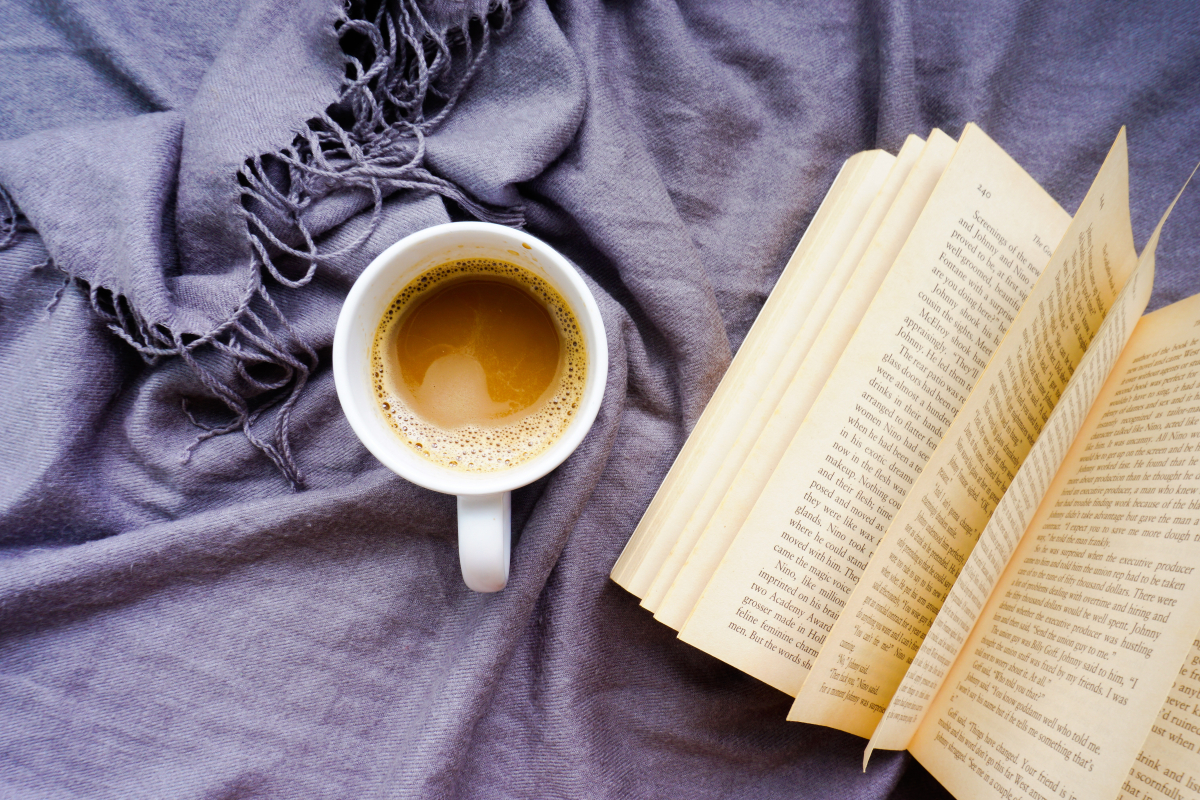 Book on a blanket with a hot beverage