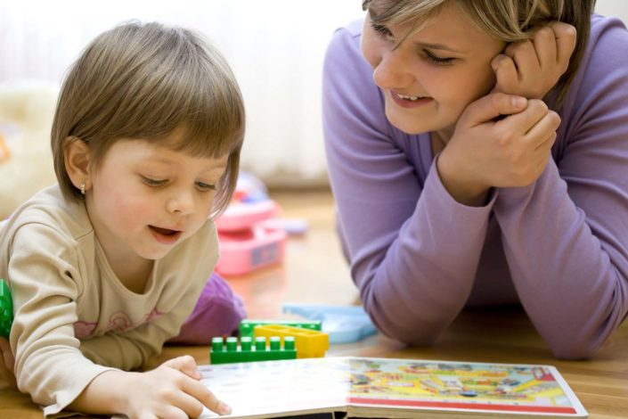 Photo of child working on a puzzle with a parent