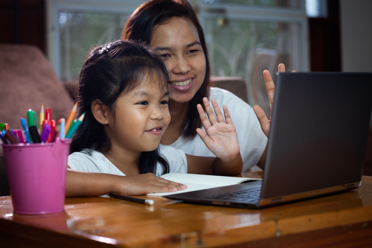 Photo of mother helping child with remote learning