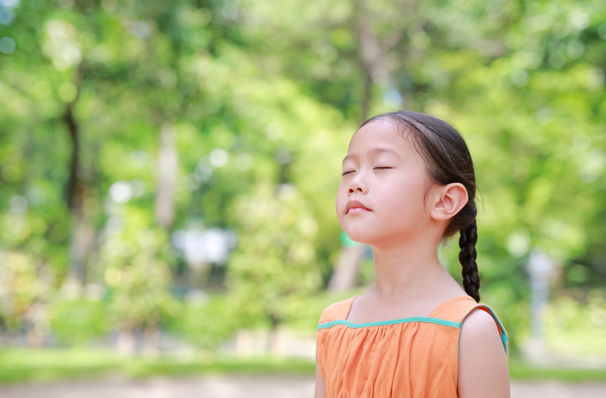 Photo of a young girl taking breaths outdoors