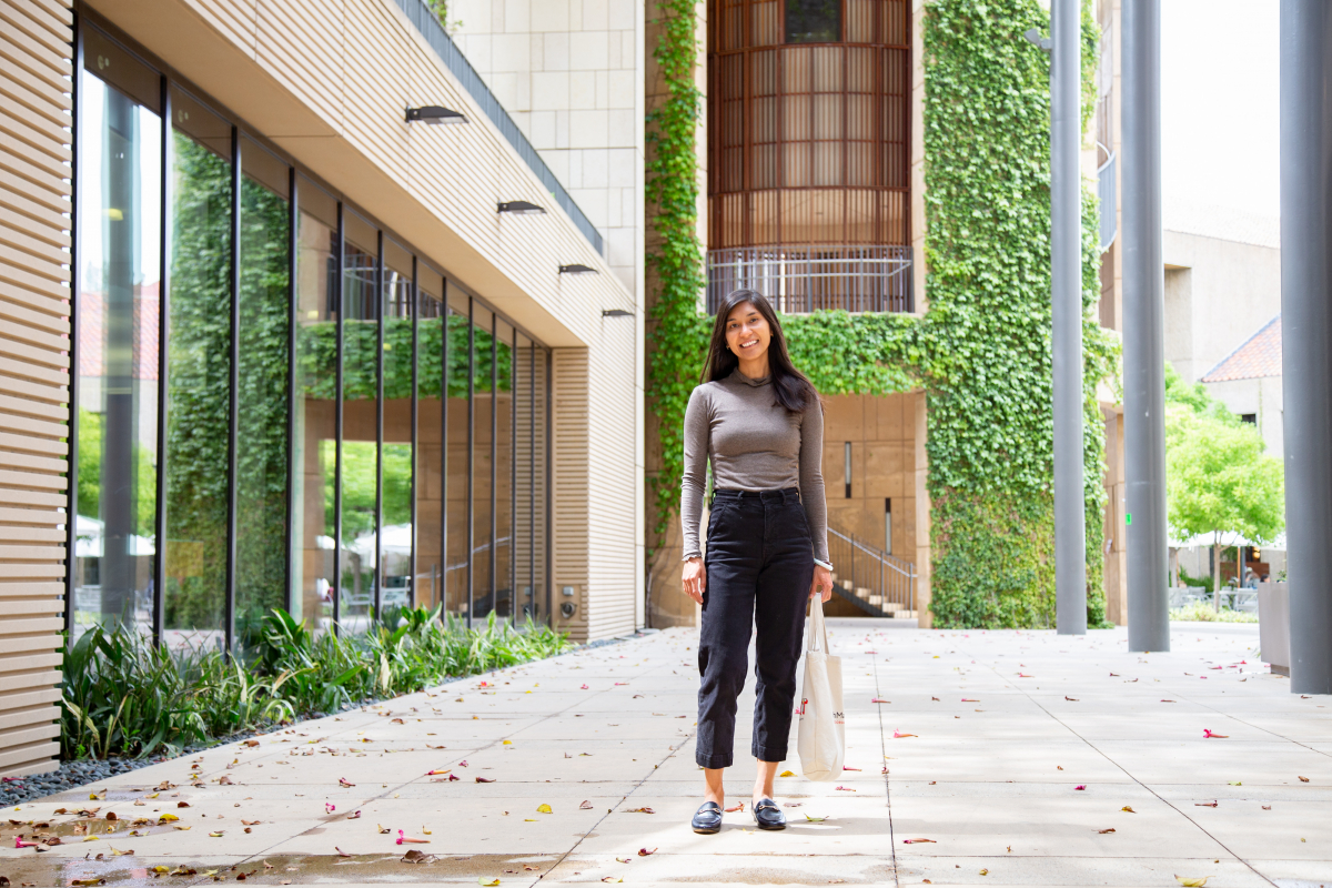 Photo of Abby Li Holst standing outside a vine-covered building at Stanford