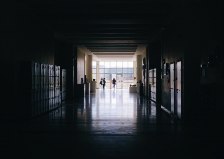 Photo of a dark school hallway opening into the light