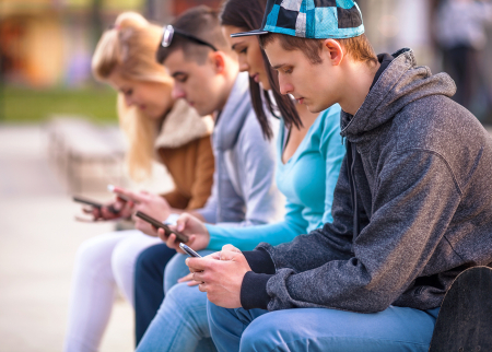 Photo of high school students reading smartphones 