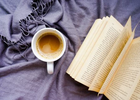 Book on a blanket with a hot beverage
