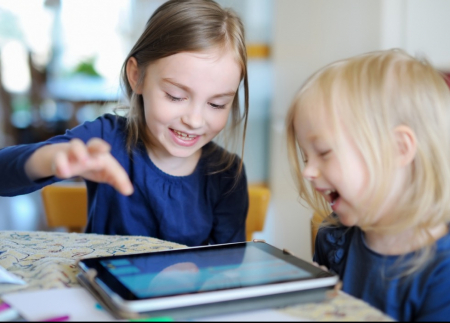 Two young girls playing on an iPad together