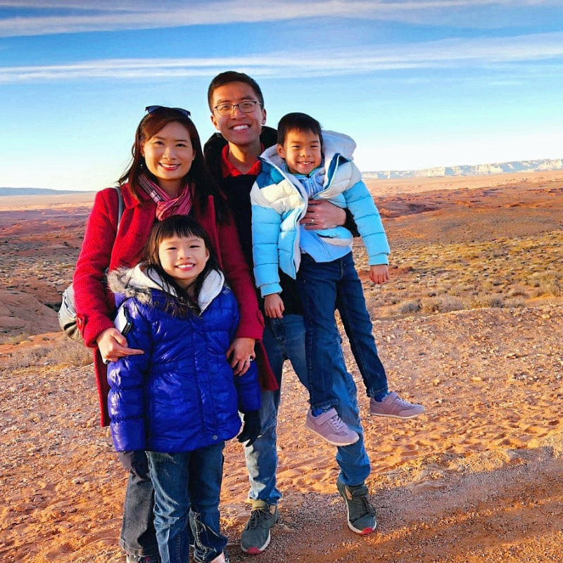 A family of four, Gabriel and Olivia and their two children, bundled up but in an arid landscape