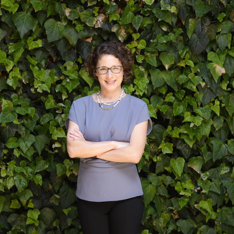 Associate Professor Emily J. Levine standing in front of a hedge of ivy