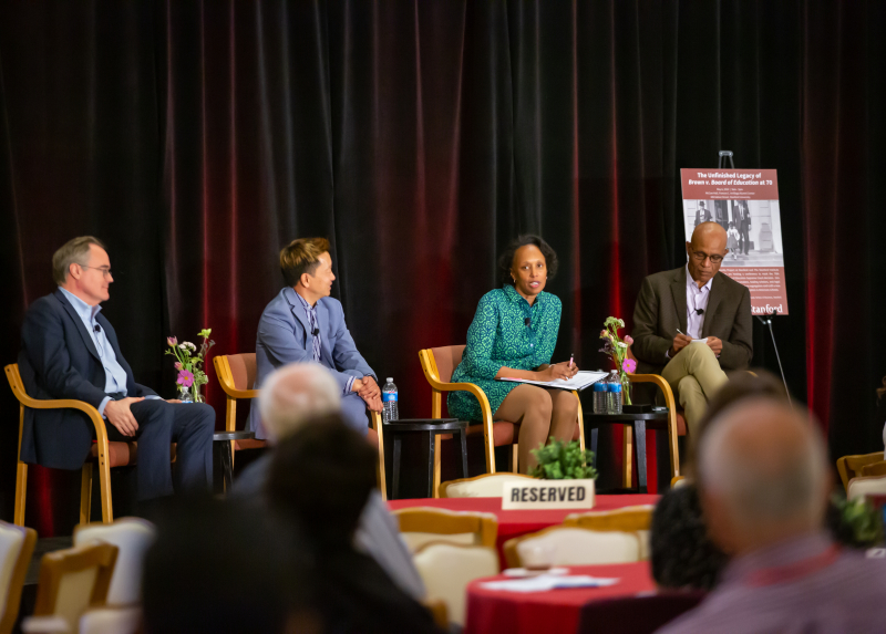 Four panelists on stage.