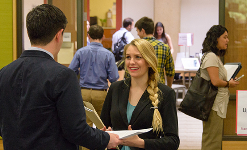 A GSE student (center) spoke with a potential employer on March 11 at a Stanford EdCareers job fair.