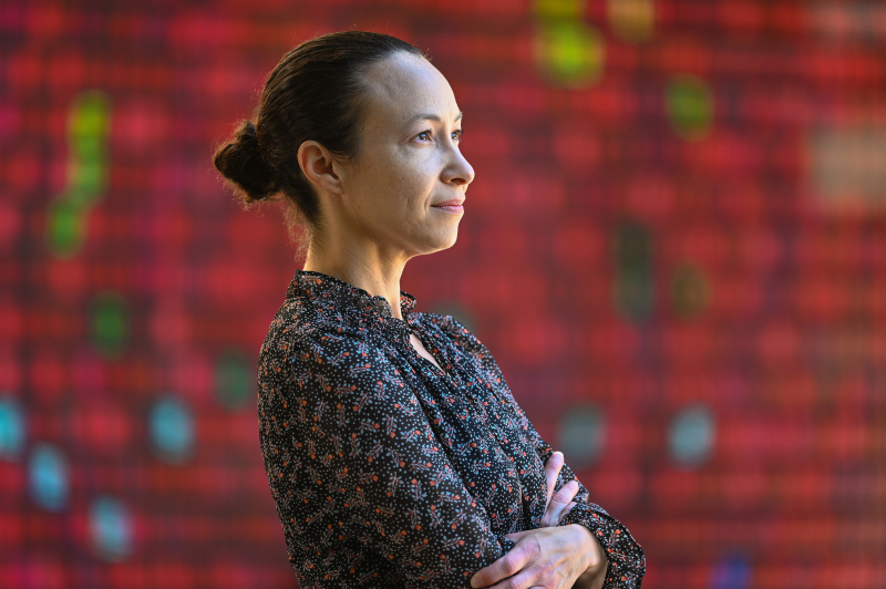 Photo of Emilie Rosales Trimble in front of artwork at the Stanford Business School—"Monument to Change as it Changes," by Peter Wegner